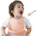 a baby eating while wearing the silicone bibs 